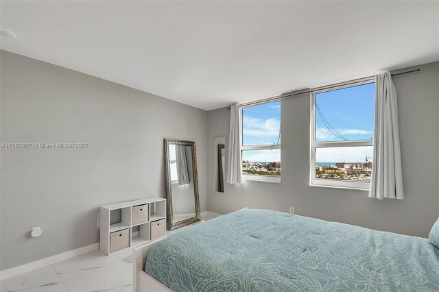 bedroom with baseboards and marble finish floor