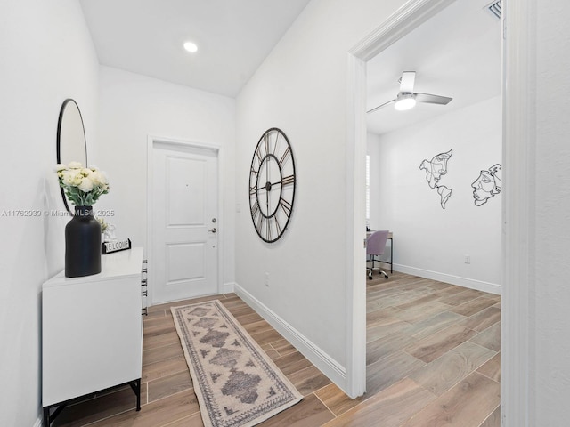 entryway featuring a ceiling fan, visible vents, baseboards, and light wood-type flooring