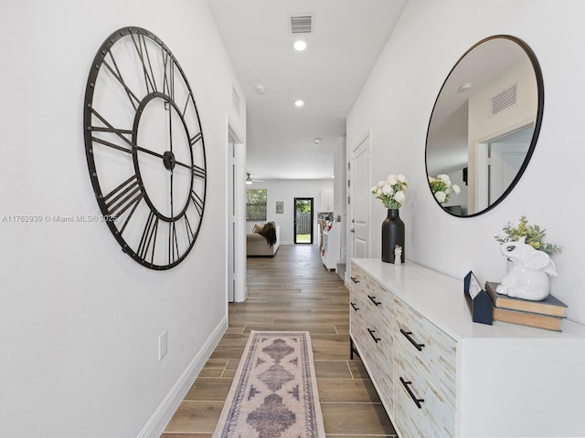 hallway with recessed lighting, visible vents, baseboards, and wood tiled floor