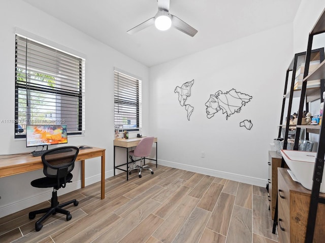 home office with a ceiling fan, baseboards, and wood tiled floor