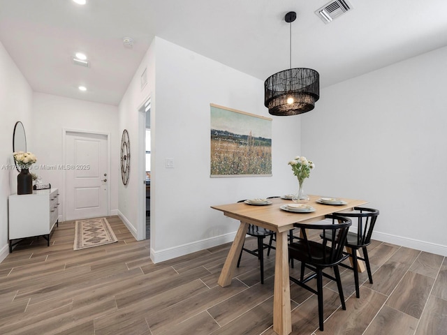 dining area with wood finish floors, visible vents, and baseboards