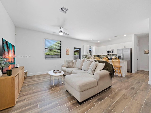 living area featuring visible vents, recessed lighting, baseboards, and wood finish floors