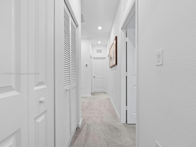 hallway with recessed lighting, baseboards, visible vents, and light carpet