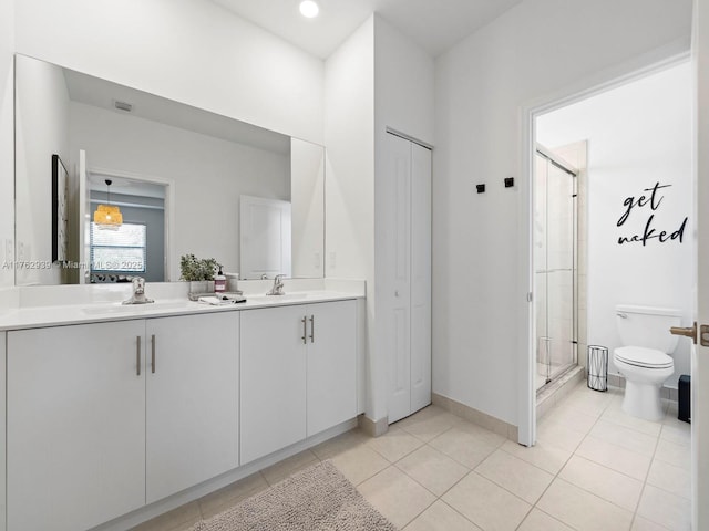 bathroom with a sink, toilet, a shower stall, and tile patterned floors