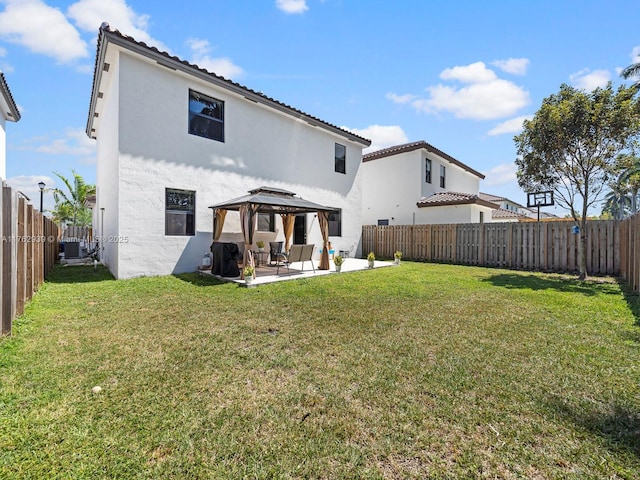 rear view of house featuring a gazebo, central air condition unit, a lawn, and a patio