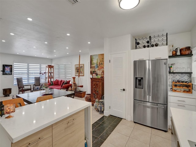 kitchen with open shelves, recessed lighting, stainless steel fridge, light countertops, and light tile patterned floors