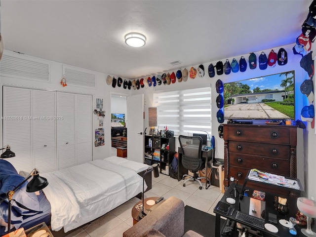 bedroom with light tile patterned flooring and a closet