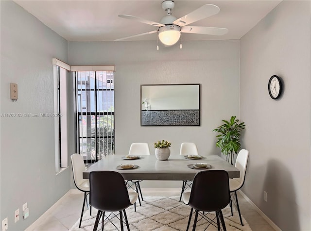 dining space featuring light tile patterned floors, baseboards, and ceiling fan