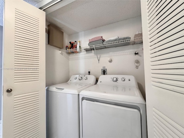 clothes washing area featuring laundry area, separate washer and dryer, and a textured ceiling