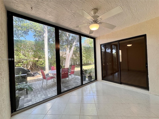 unfurnished sunroom featuring plenty of natural light and ceiling fan