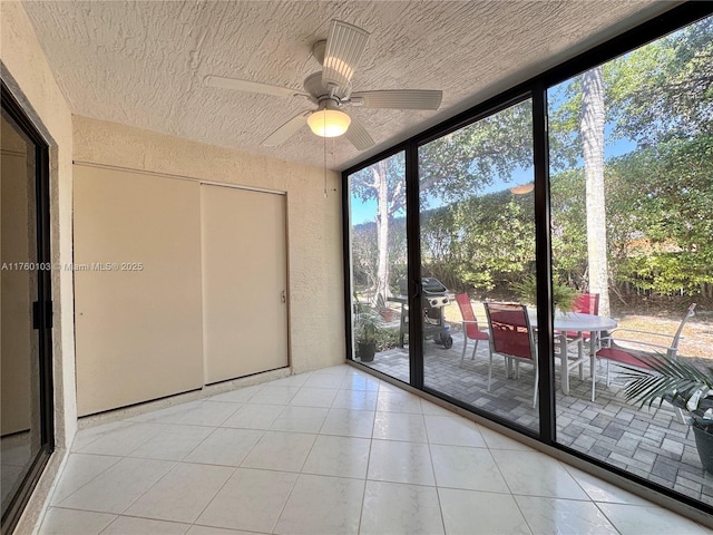 unfurnished sunroom with a ceiling fan