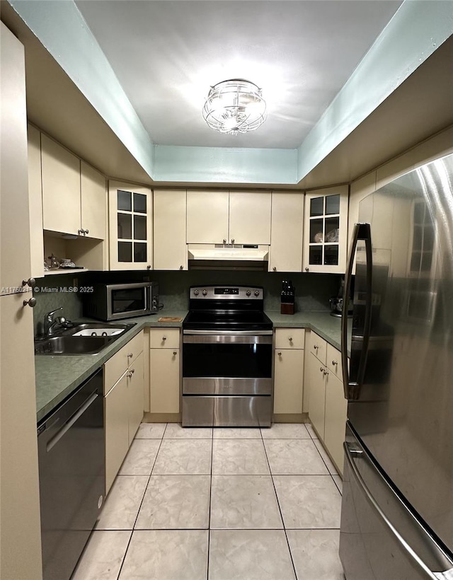 9015 SW 125th Ave Unit N109, Miami, FL 33186 - kitchen featuring a sink, light tile patterned floors, appliances with stainless steel finishes, cream cabinetry, and under cabinet range hood