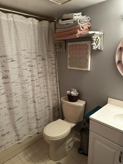 full bath with toilet, shower / bath combination with curtain, vanity, and tile patterned flooring