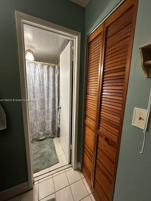 bathroom featuring a shower with shower curtain and tile patterned flooring