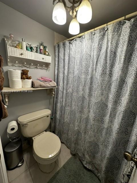 full bath with tile patterned flooring, curtained shower, and toilet