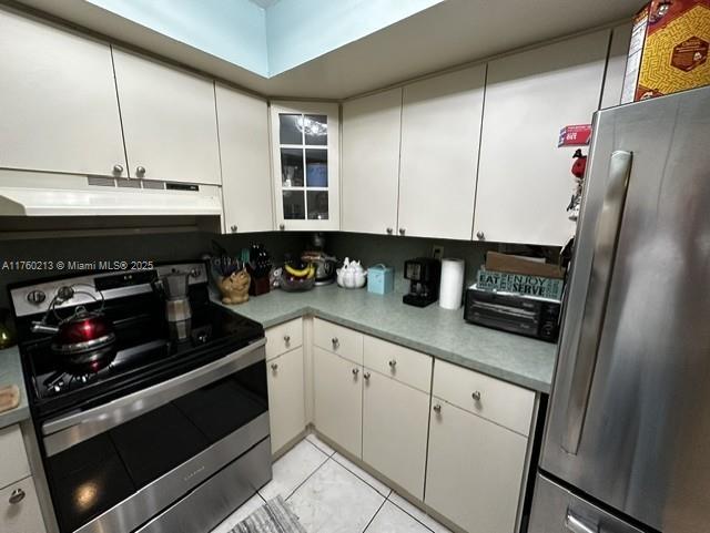 kitchen featuring under cabinet range hood, white cabinets, appliances with stainless steel finishes, and light countertops