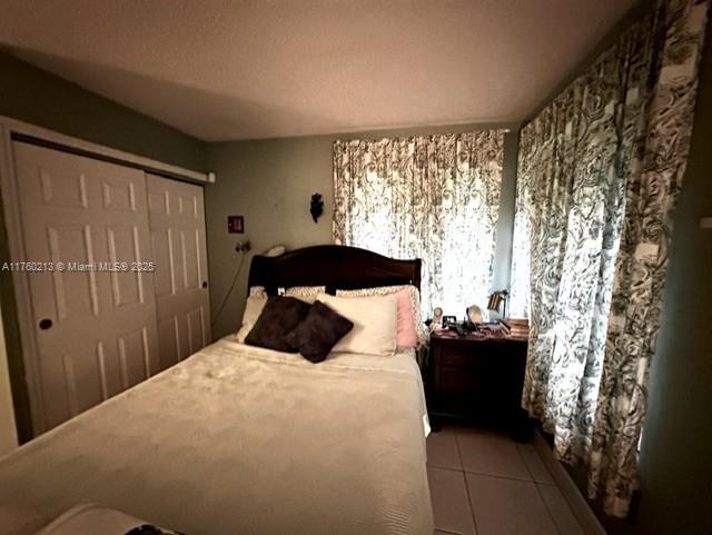 tiled bedroom with a closet