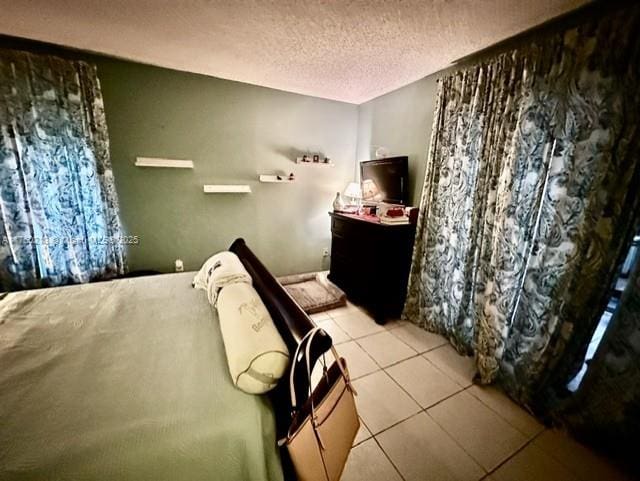 bedroom featuring light tile patterned floors and a textured ceiling