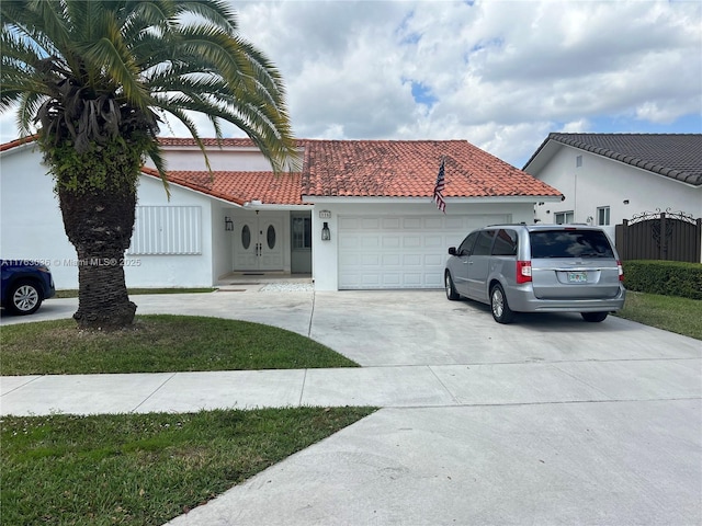 view of front of home featuring stucco siding, an attached garage, a tile roof, and concrete driveway