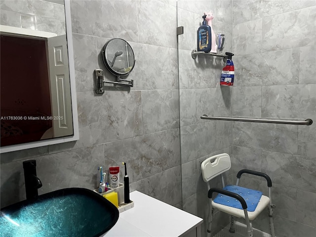 bathroom featuring a sink and tile walls