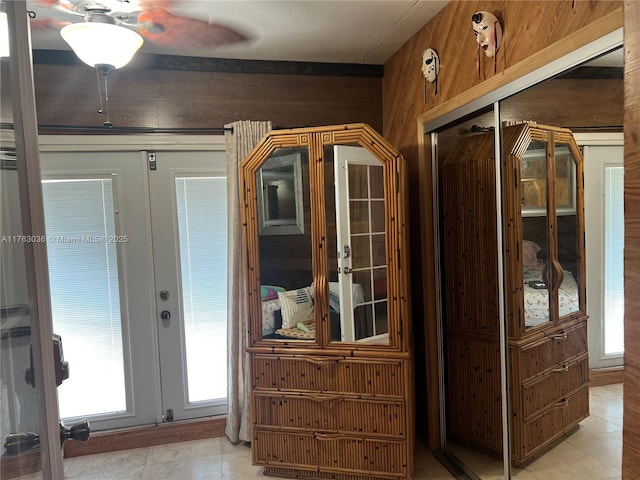 foyer entrance featuring french doors, wood walls, and a healthy amount of sunlight