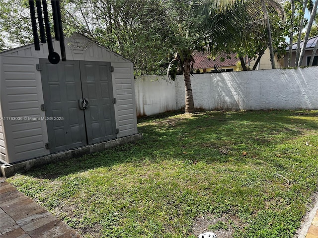 view of yard featuring an outbuilding, a storage shed, and a fenced backyard