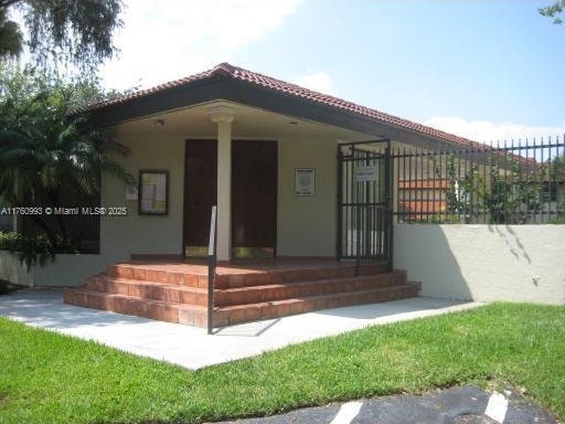 rear view of property with covered porch, a tile roof, and stucco siding