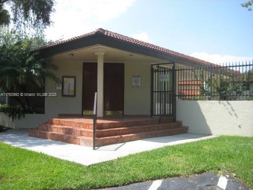 entrance to property with a tiled roof, covered porch, and stucco siding