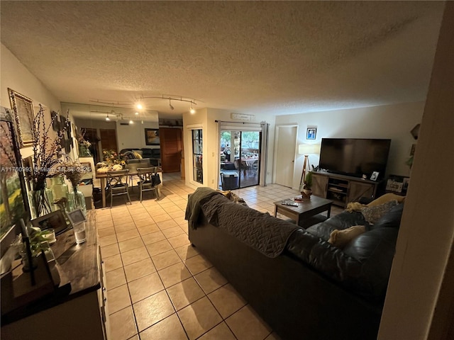 living area featuring light tile patterned floors, track lighting, and a textured ceiling