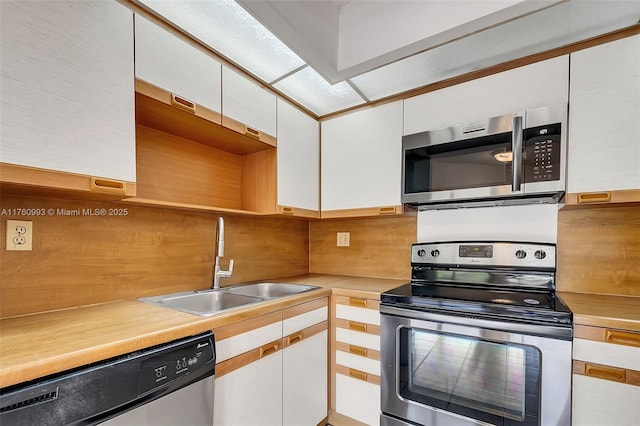 kitchen featuring a sink, appliances with stainless steel finishes, white cabinets, and light countertops