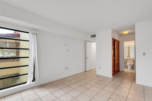 unfurnished room featuring visible vents and light tile patterned flooring
