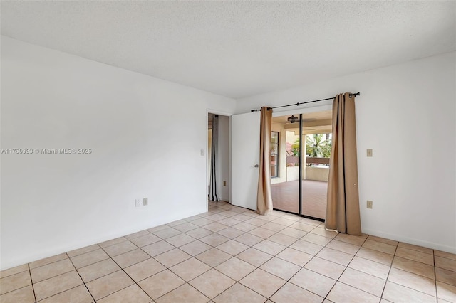 empty room with light tile patterned floors and a textured ceiling