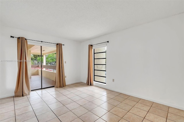 empty room with light tile patterned floors and a textured ceiling