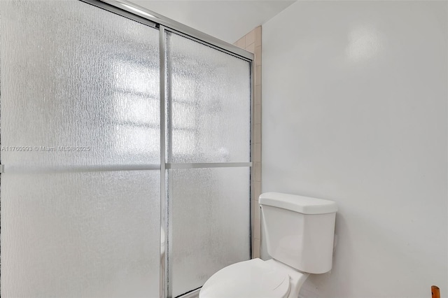 full bathroom with a stall shower and toilet