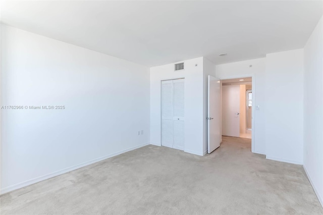 unfurnished room with light carpet, visible vents, and baseboards