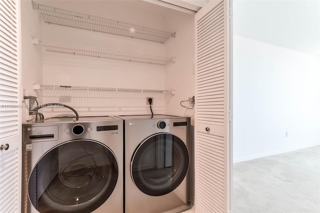 clothes washing area with laundry area, baseboards, carpet floors, and washing machine and clothes dryer