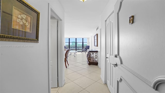 corridor with light tile patterned floors, expansive windows, and visible vents