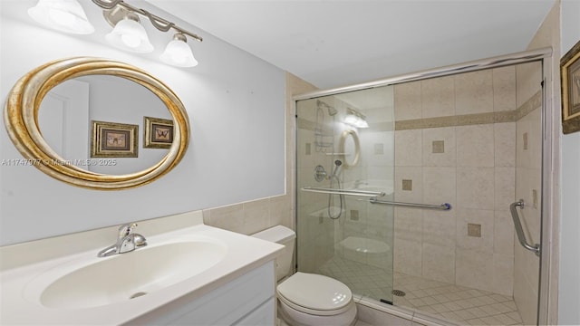 full bathroom featuring vanity, a shower stall, and toilet