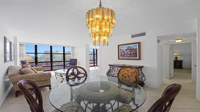 dining area featuring baseboards, visible vents, an inviting chandelier, a high ceiling, and light tile patterned flooring