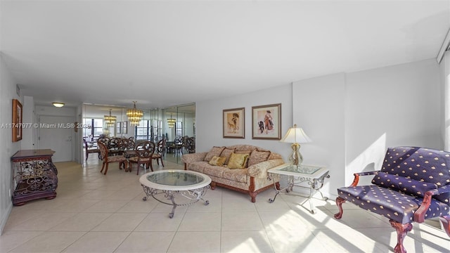 living area with tile patterned flooring and a notable chandelier