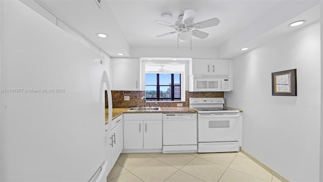 kitchen featuring light tile patterned floors, decorative backsplash, white appliances, white cabinetry, and a sink