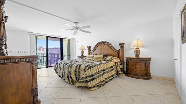 bedroom featuring baseboards, a wall of windows, light tile patterned floors, a ceiling fan, and access to outside