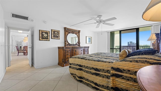 bedroom featuring visible vents, a view of city, access to exterior, light tile patterned flooring, and ceiling fan