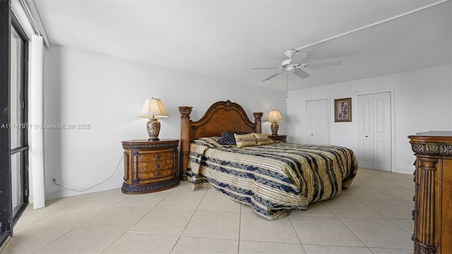 bedroom with light tile patterned floors, two closets, and ceiling fan