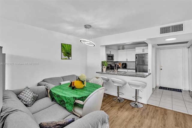 living room featuring visible vents and light wood-style floors