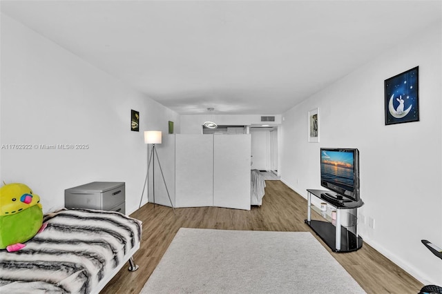 bedroom featuring visible vents, baseboards, and wood finished floors