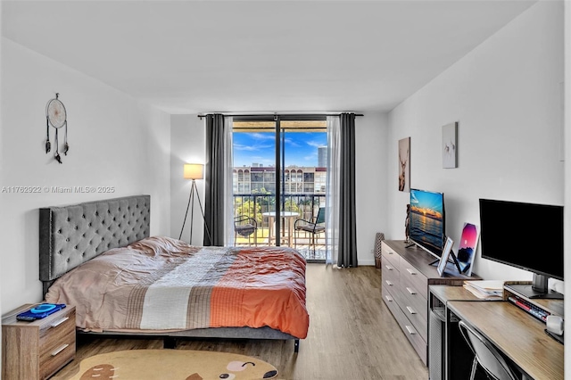 bedroom with access to exterior, floor to ceiling windows, light wood-type flooring, and baseboards