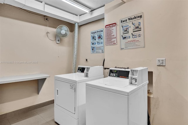 common laundry area featuring light tile patterned floors, independent washer and dryer, and baseboards