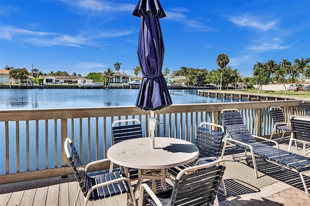 wooden deck with outdoor dining space and a water view