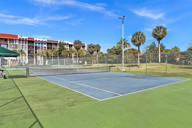 view of tennis court featuring fence